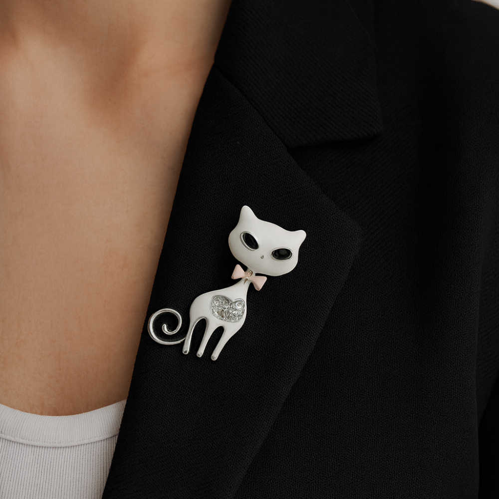 An elegant brooch in the shape of a white cat — a stylish and delicate accessory with sparkling rhinestones and a cute pink bow. (6745)